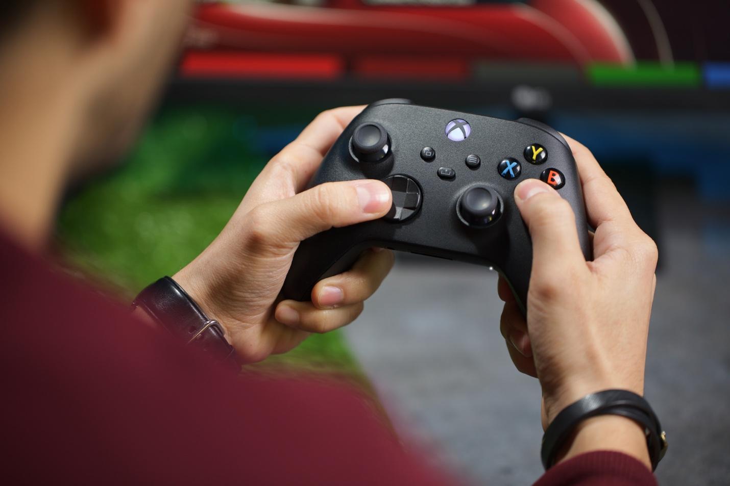 Una persona que sostiene un controlador de videojuego Descripción generada automáticamente