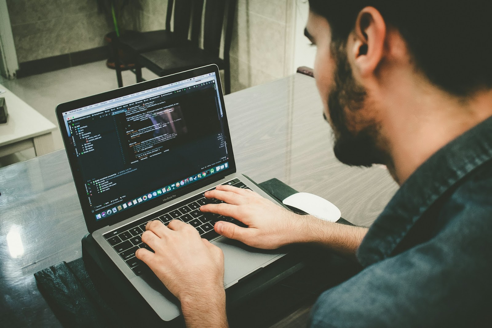 un hombre escribiendo en una computadora portátil