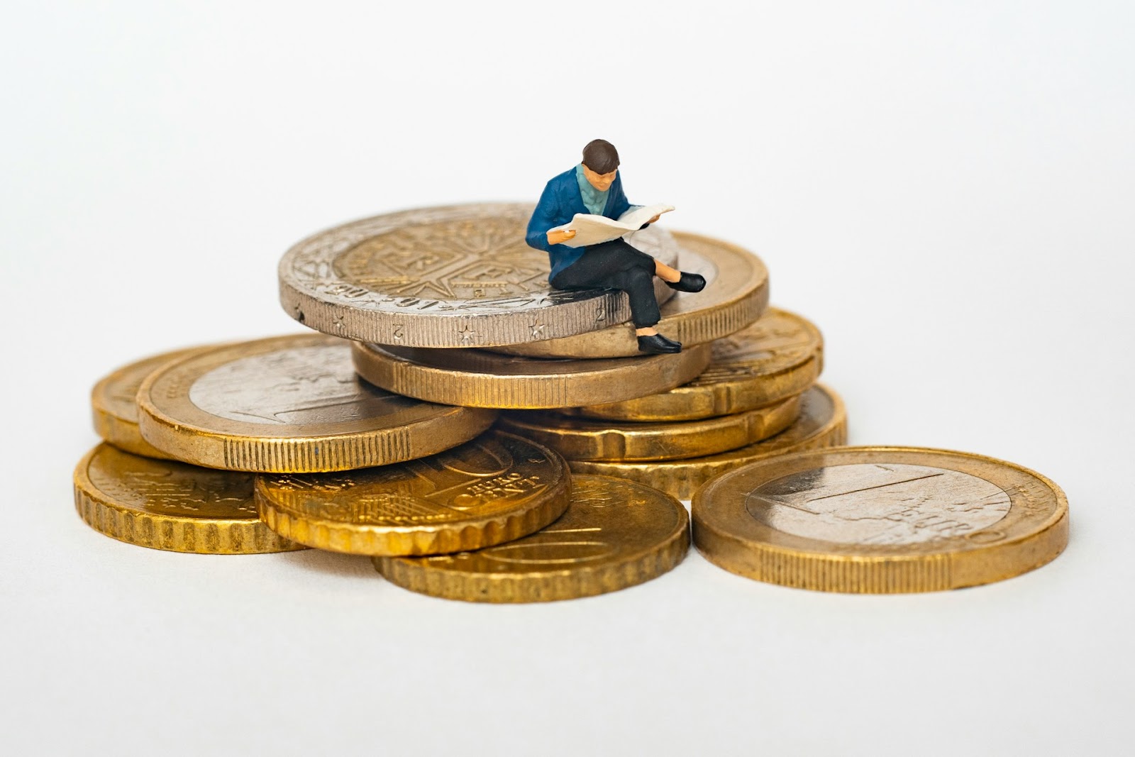 una figura de un hombre sentado sobre monedas
